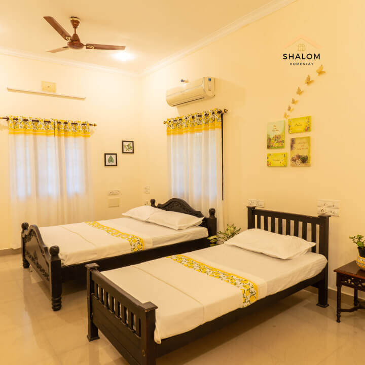 Two twin beds in a room with a clock on the wall.